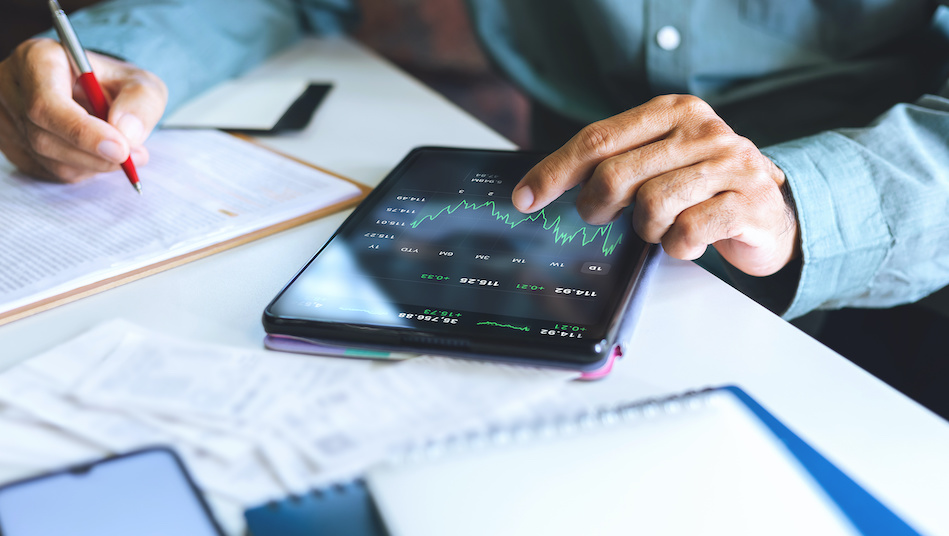 Asian businessman assessing his investments on a tablet computer