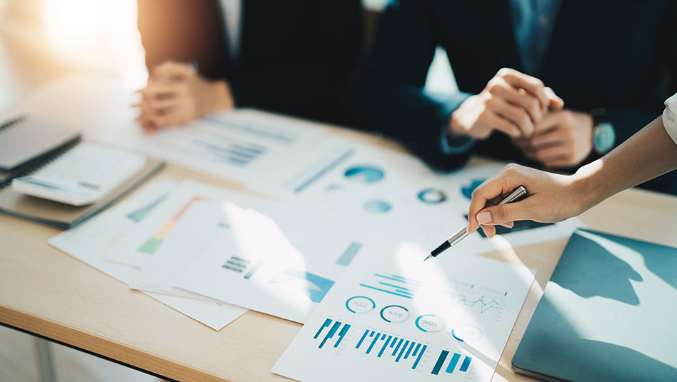 People examining printed charts on a table
