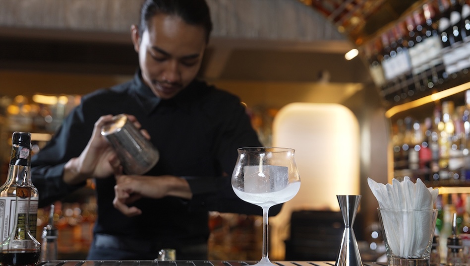 A man preparing a drink at a bar